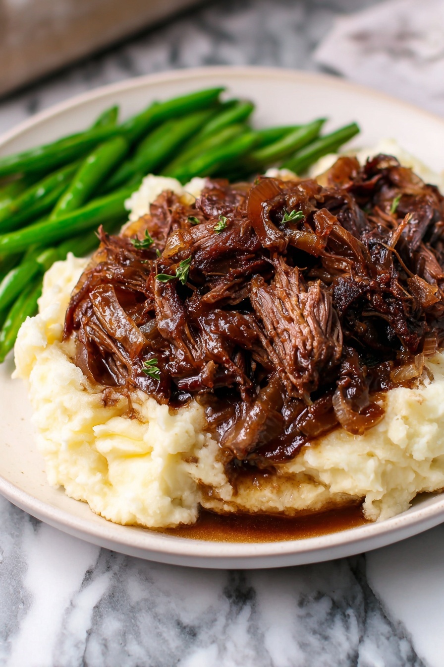 The dish shows a white plate with three main layers: at the bottom is a thick layer of creamy mashed potatoes that look smooth and soft, the middle layer consists of dark brown shredded beef with some glossy sauce around it, and on the left side of the plate, there are bright green cooked green beans. The mashed potatoes cover most of the plate with the beef piled on top in an uneven mound, while the green beans are neatly placed beside it. The setting has a warm light with a blurred background that includes brownish shapes, all on a white marbled texture surface. photo taken with an iphone --ar 2:3 --v 7
