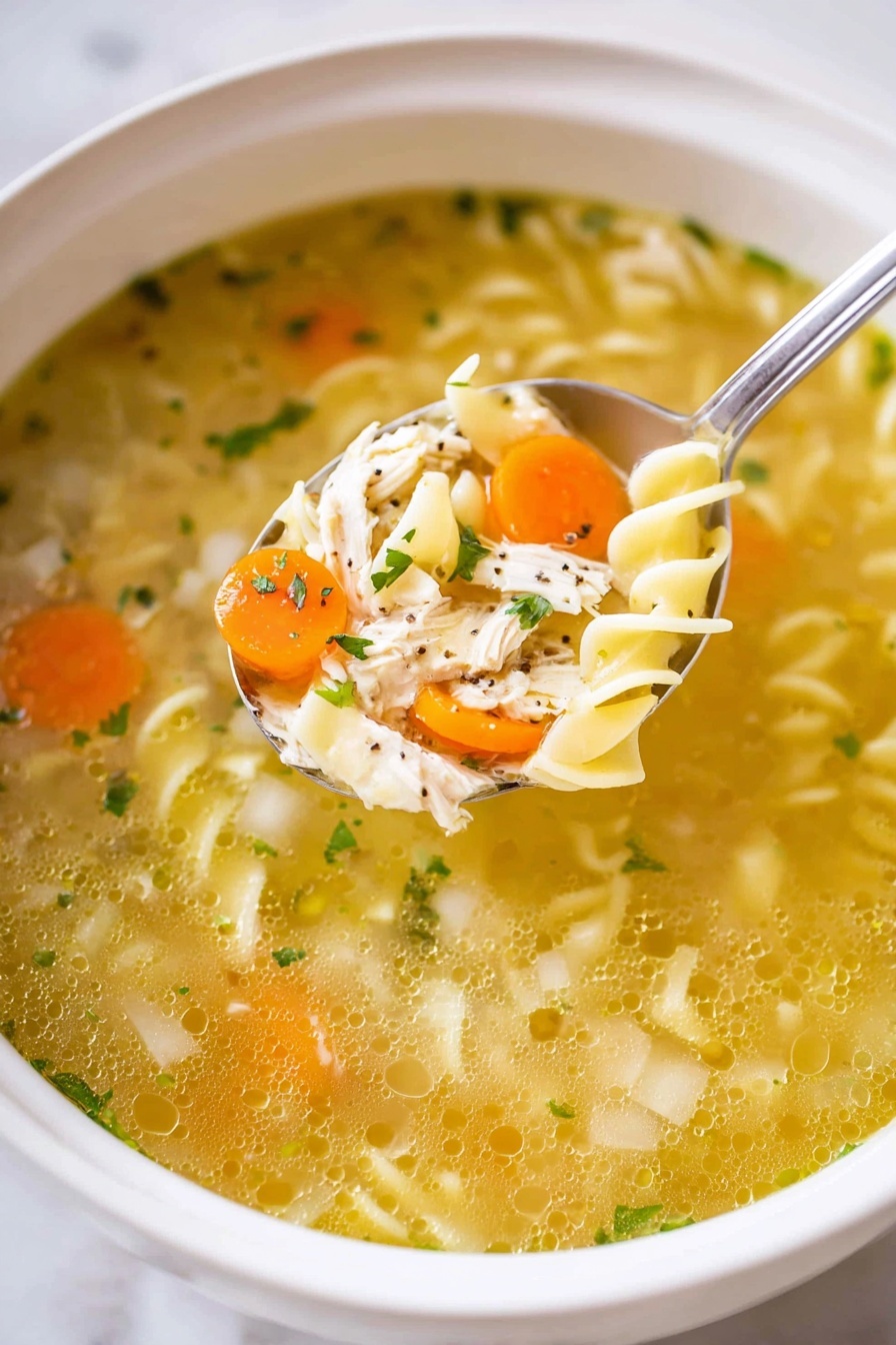 A white bowl filled with clear golden broth soup, showing three layers: the top layer is sprinkled with green herbs, the middle layer has small diced white onions, bright orange carrot slices, and pale green celery pieces floating evenly, and the bottom layer contains tender white shredded chicken and curly egg noodles. A silver spoon scoops a mix of these ingredients, highlighting the texture of soft carrots, smooth celery, plump noodles, and shredded chicken all immersed in the clear broth, against a white marbled texture surface. Photo taken with an iphone --ar 2:3 --v 7