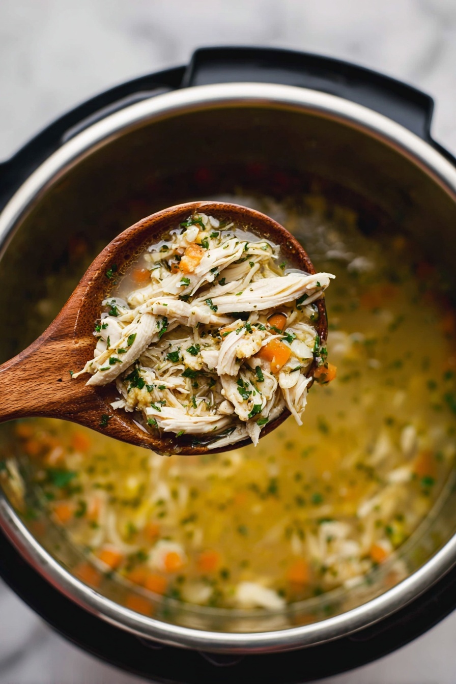 A wooden spoon filled with a clear soup holds shredded white chicken, small orange carrot pieces, green herbs, and thin slices of light green vegetable, all mixed in a light broth. The spoon is held above a silver metal pot with a black outer rim, which contains more of the soup with the same ingredients blurred in the background. The whole scene is set on a surface with a white marbled texture. photo taken with an iphone --ar 2:3 --v 7