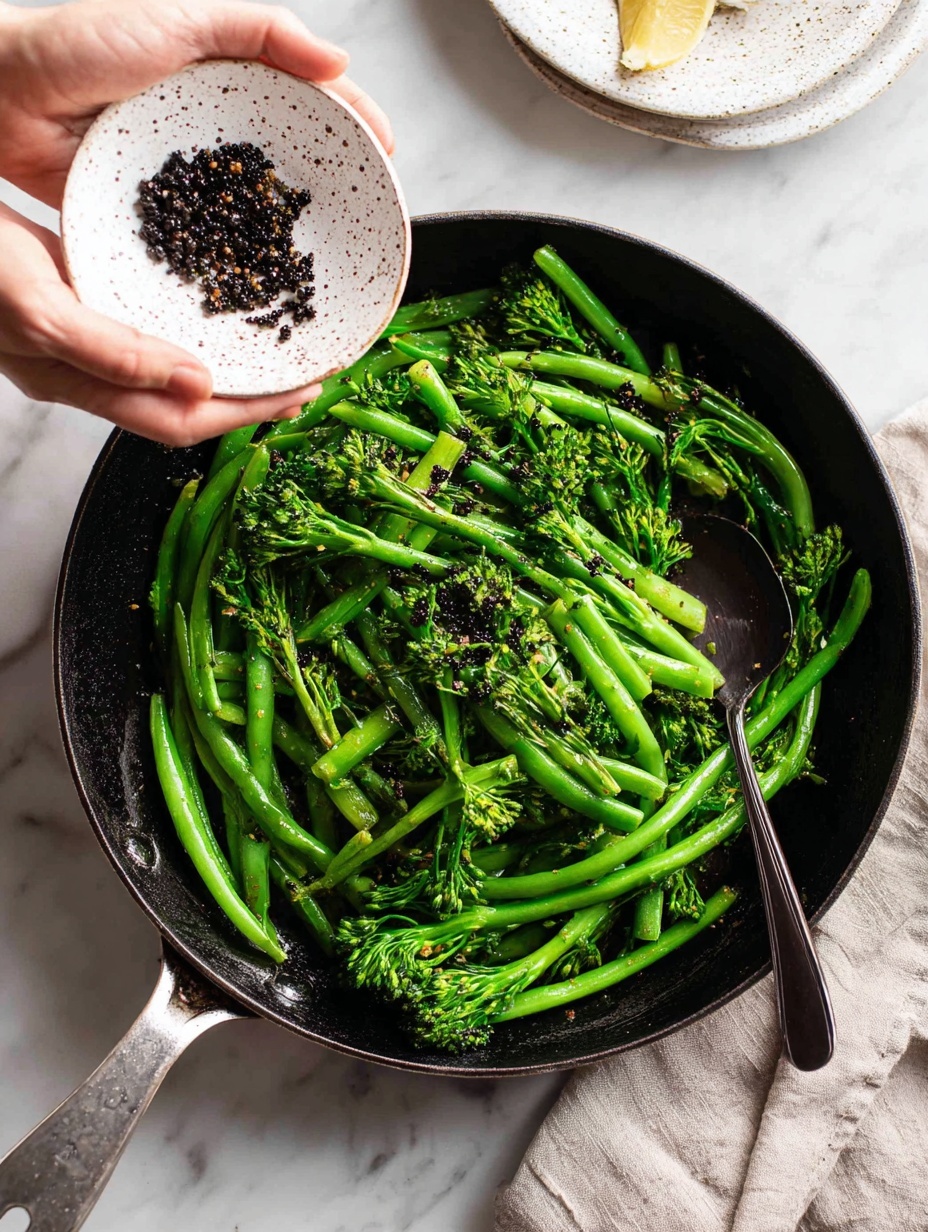 A stainless steel pan shows bright green steamed broccolini and green beans, arranged loosely with some stems crossing each other. A white bowl held by a woman's hand tips small, dark reddish-brown lentils into the pan over the vegetables. Inside the pan, a black spoon rests among the green vegetables, catching some lentils mid-pour. The scene is set on a white marbled surface with soft, natural lighting highlighting the fresh, glossy texture of the vegetables and the matte, slightly rough look of the lentils. photo taken with an iphone --ar 2:3 --v 7