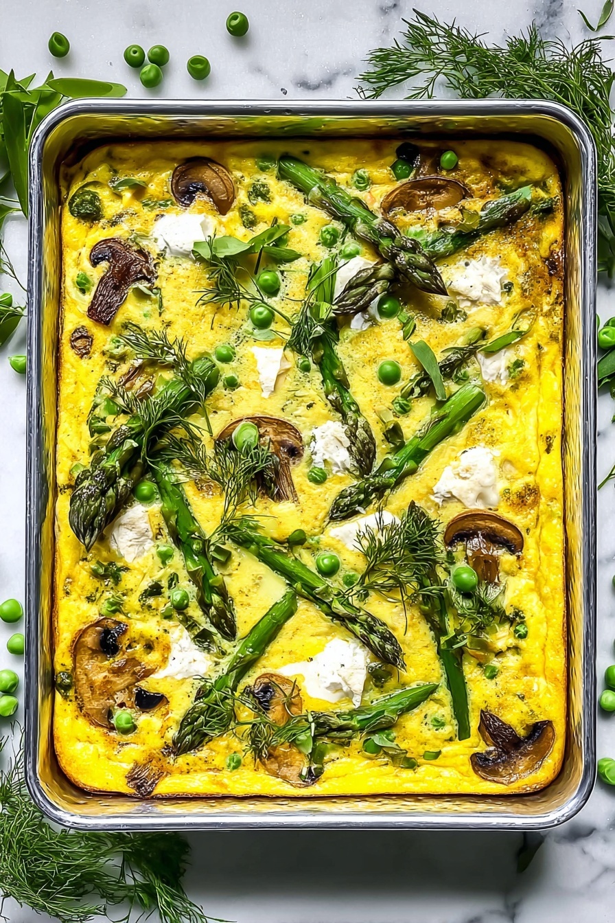 A rectangular metal baking tray filled with a bright yellow baked dish, which is about one layer thick, showing a mix of green peas, asparagus spears, and wilted spinach evenly spread throughout. Small white dollops of cheese are scattered on top, and there are browned slices of mushrooms visible near the edges. Fresh green herbs, like dill and parsley, are sprinkled across the surface and around the corners of the tray. The tray is placed on a white marbled textured cloth with some loose green peas and asparagus tips nearby. Photo taken with an iphone --ar 2:3 --v 7