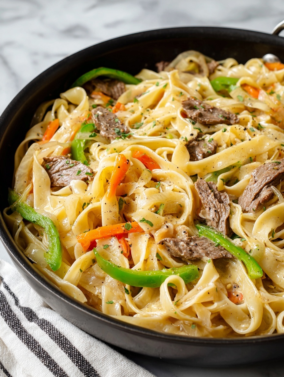 The image shows a close-up of a black skillet filled with wide, flat noodles that are creamy light yellow in color and have a soft texture. Mixed throughout are several slices of browned strips of beef, cooked with soft, translucent onion strips that have light brown caramelized edges. Bright green bell pepper slices add a pop of color, scattered evenly over the noodles. Some black pepper is sprinkled on top, adding small dark specks across the dish. The skillet sits on a wooden surface with a white marbled texture underneath, suggesting a cozy kitchen setting. Photo taken with an iphone --ar 2:3 --v 7