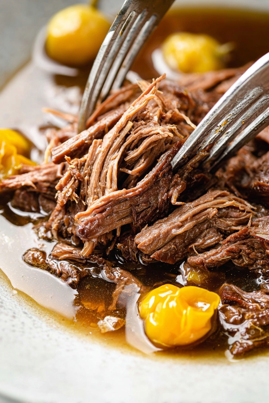 The image shows a white round plate with two main layers; the bottom layer is smooth, creamy white mashed potatoes spread evenly in a circular shape with soft peaks. On top, there is a generous pile of dark brown shredded meat, looking tender and juicy with a slightly glossy texture from the juice surrounding it. Among the meat, there are three bright yellow pickled peppers that add a pop of color. Small green herb bits are sprinkled across the meat and mashed potatoes for contrast. A fork with a wooden handle rests on the left side of the plate, placed on a white marbled surface with some fresh green herbs scattered around. Photo taken with an iphone --ar 2:3 --v 7